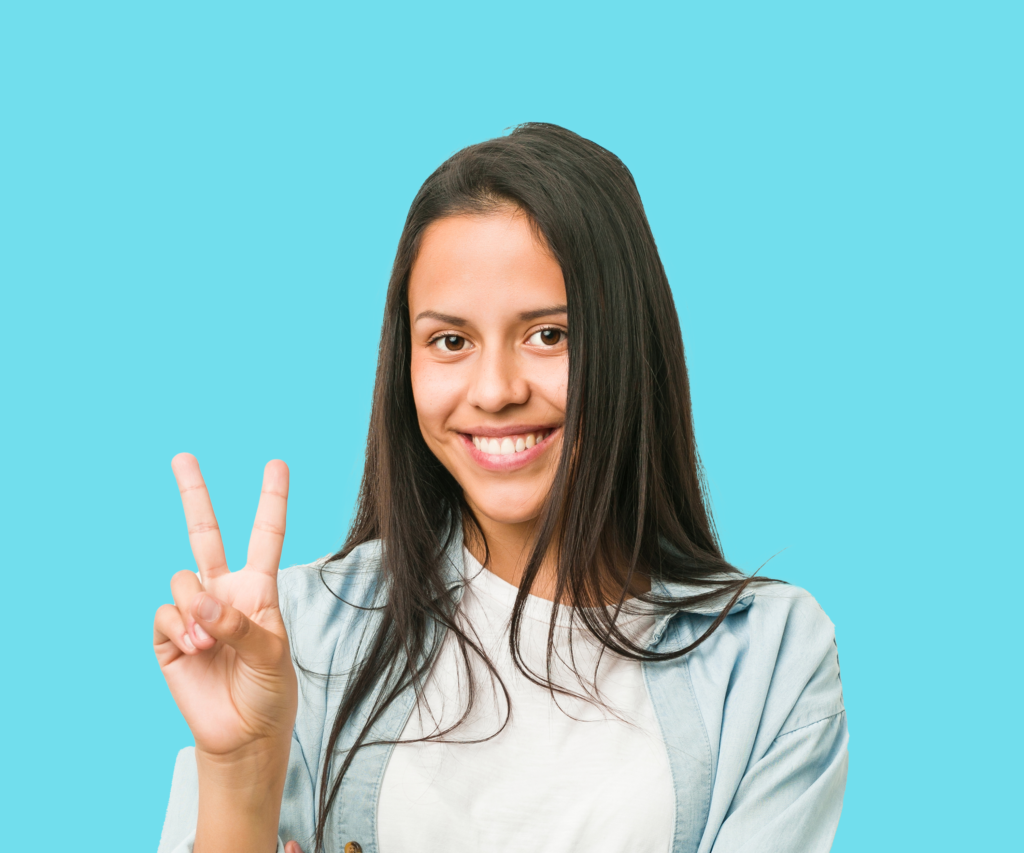 Teenage Girl smiling holding up a peace sign