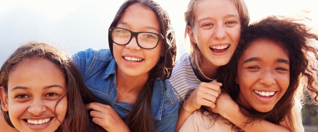 teens pose for a selfie talking about Invisalign buttons vs. attachments